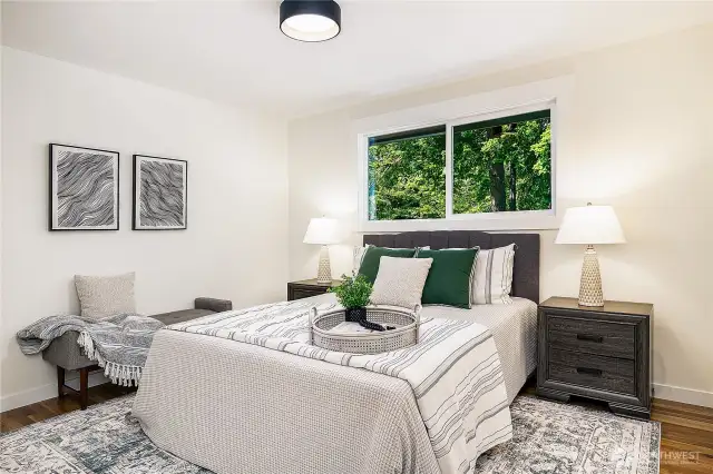 Spacious primary bedroom with a window overlooking the back yard and deck. En-suite bath located just to the right, just out of frame