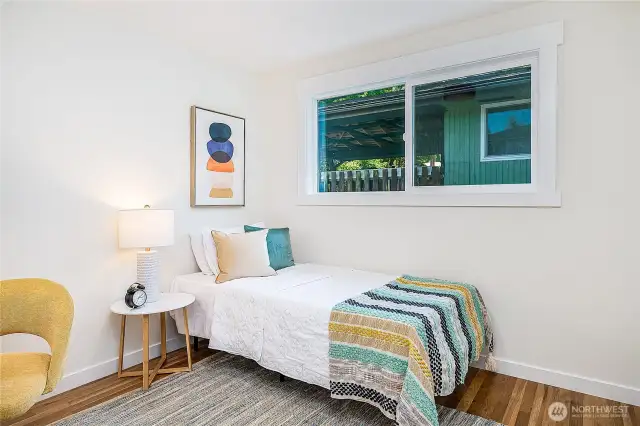 "Third bedroom on the main level with a south-facing window. Just out of frame on the left is a cozy nook, ideal for a desk and chair.