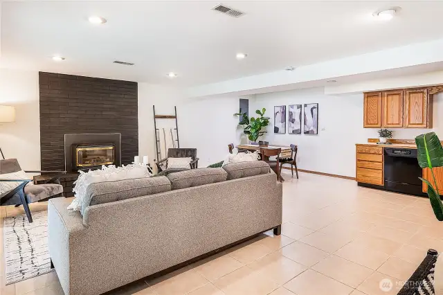 Spacious downstairs living area featuring a full kitchen and a separate entrance with slider to the backyard (just out of frame). Perfect as guest quarters or a potential Airbnb with a cozy fireplace and dining space.