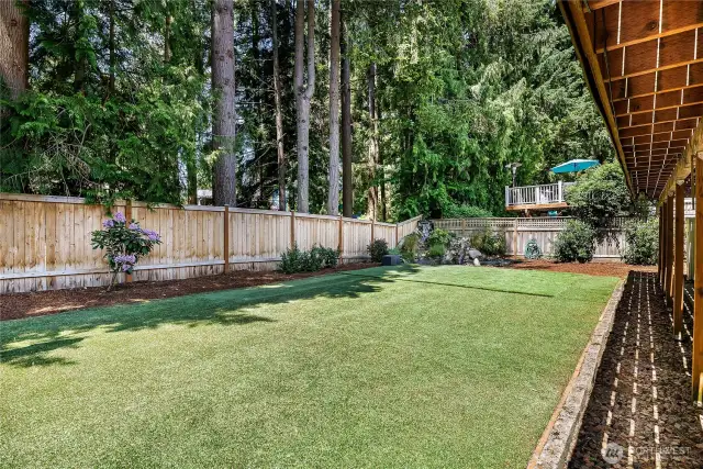 Another view of the low-maintenance turf with a newer wood fence in excellent condition. Enjoy the serene pond and waterfall nestled in the back corner.