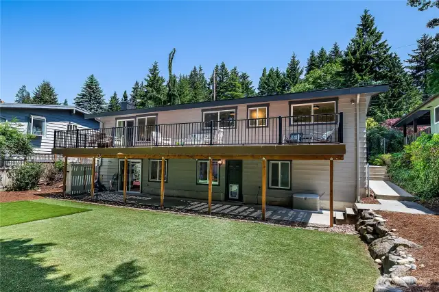 Eye-level view of the back of the house showing the daylight basement and convenient sidewalk access to the downstairs entrance.