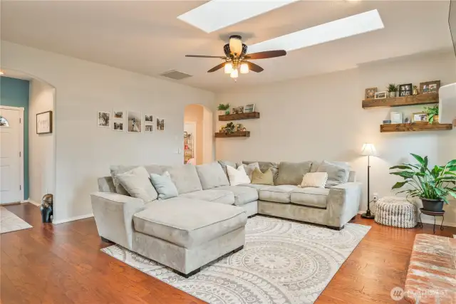 Living room with engineered hardwood floors and skylights