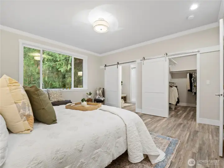 The primary suite has a large walk-in closet. Both the closet and the primary bath has beatiful barndoors.