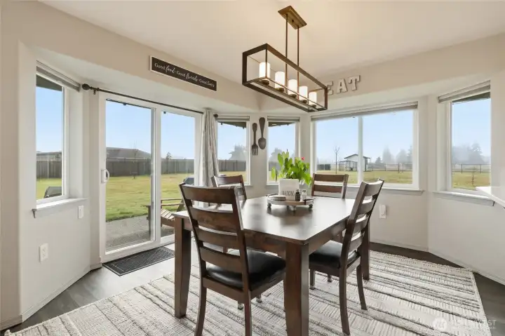 Wonderful dining space with wide bay windows and modern fixture.  The home has been outfitted with pull down shades that offer insulation and room darkening when desired.  The privacy of the property means they are rarely needed!