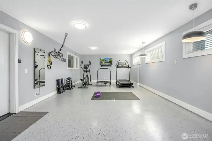 Attached heated flex space with epoxy floor currently housing in-home gym but can accommodate 2-cars tandem for a collector car showcase or ???