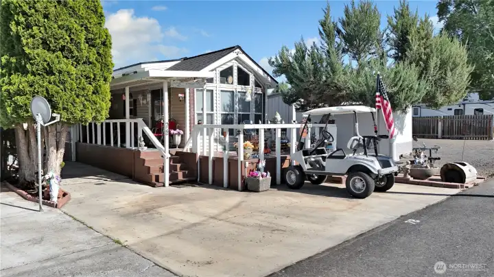 Park model home with low-maintenance asphalt and concrete lot