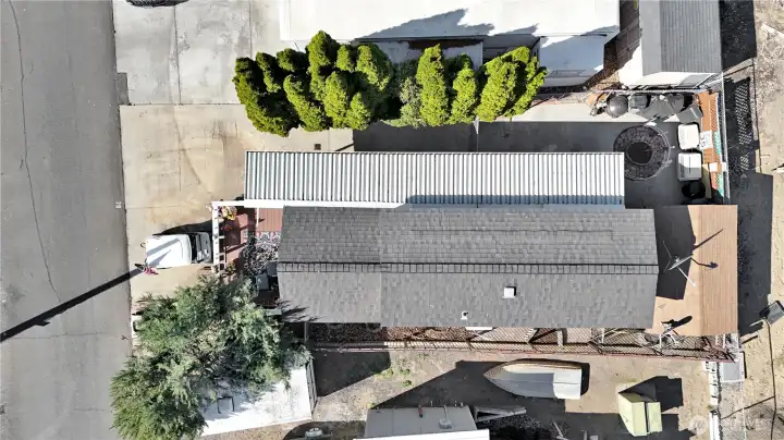 Overhead view showing full lot layout with asphalt and concrete surfaces, patio area, and boat parking configuration