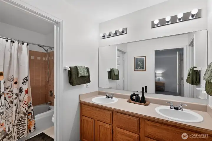 Primary bathroom with separate vanity and shower spaces.
