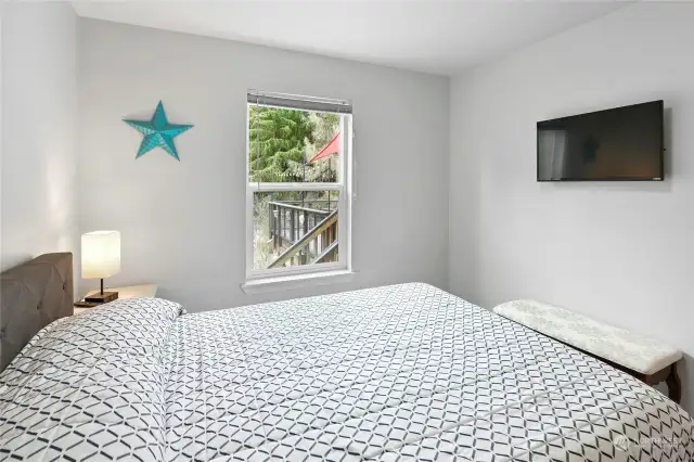 Bedroom on the second level off the kitchen. Stairs to the entertainment deck and kitchen back door seen from the window.