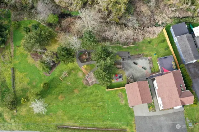 Drone view of the house, garage, deck and landscaping.