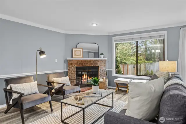 Living room has a wood burning fireplace, natural light and door to the back yard.