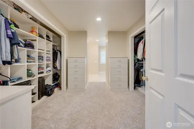 Spacious primary walk in closet with custom storage solutions