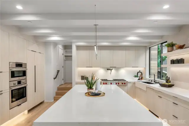 Gourmet Kitchen: Cook and entertain in style with a gourmet kitchen featuring a stunning waterfall quartz countertop and built-in refrigerator.