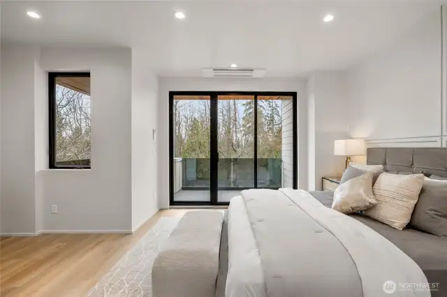 The large primary bedroom features a sliding door that opens to a private deck, offering a personal outdoor escape.