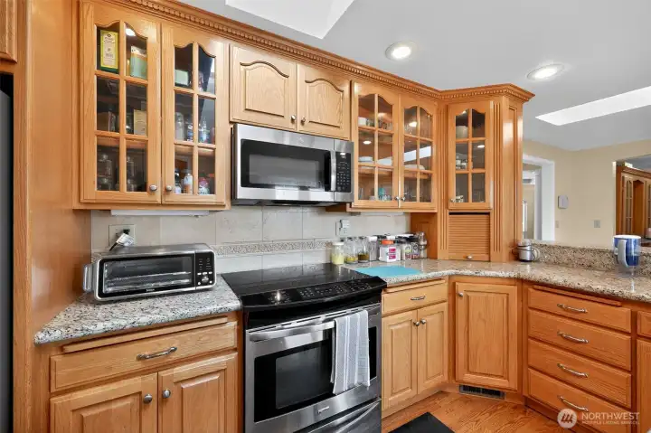 The large kitchen offers oak cabinetry, granite countertops, a roomy pantry, and a breakfast bar for casual dining