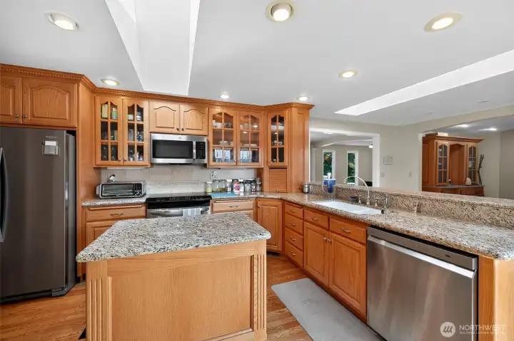 The large kitchen offers oak cabinetry, granite countertops, a roomy pantry, and a breakfast bar for casual dining