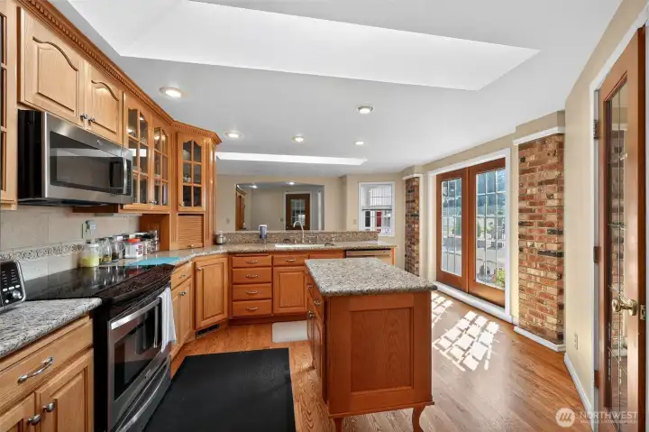 The large kitchen offers oak cabinetry, granite countertops, a roomy pantry, and a breakfast bar for casual dining