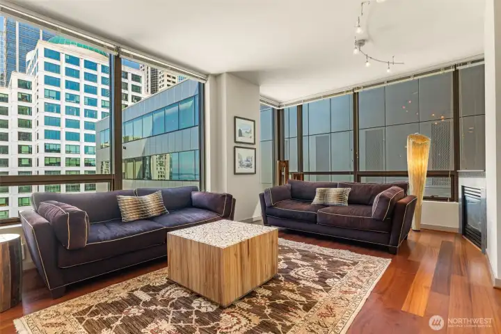 Corner window walls and high ceilings frame this spacious living space.