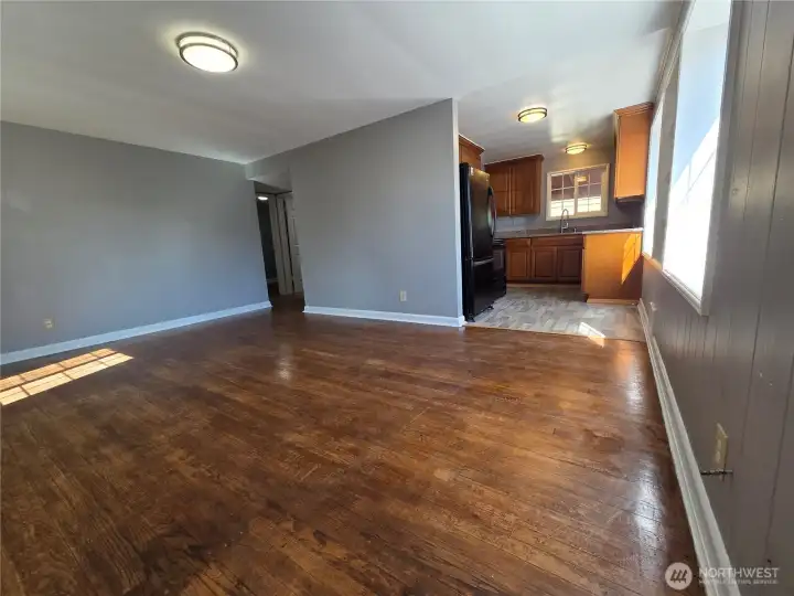 Upstairs unit at front door looking into living room and towards kitchen. Nice original hardwood floors
