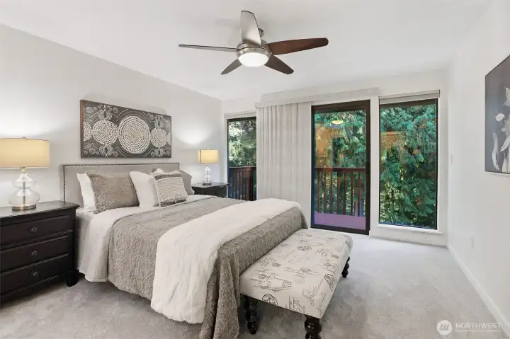 A sliding door leads to a private balcony with views of the towering evergreens.