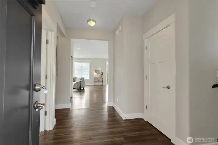 Entry into home with one bedroom to the left, large hall closet/storage on the right and open great room/kitchen area off the back of the home.