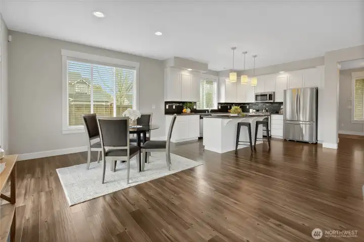 Looking into dining and kitchen space from back window.  Home offers great natural lighting.