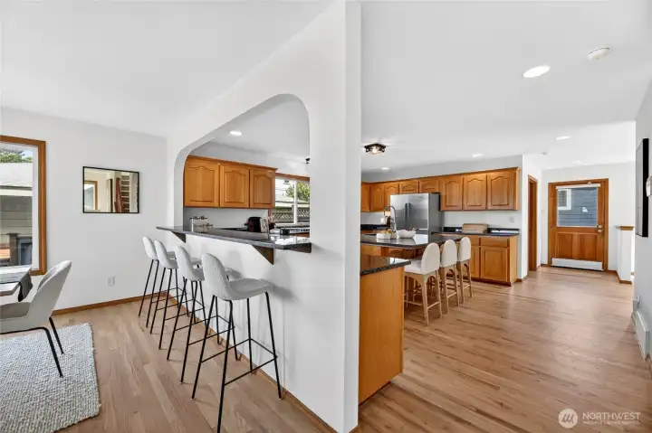 Spacious chef’s kitchen with abundant cabinetry, oversized breakfast bar seating, and an open layout designed for effortless gathering and entertaining.
