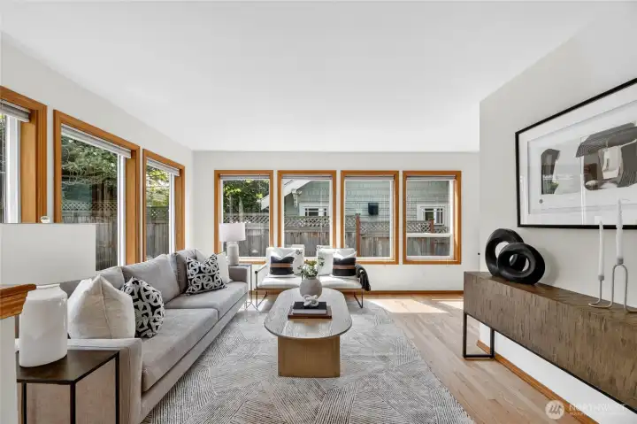 Sun-drenched family room with walls of windows, warm hardwoods, and inviting spaces designed for relaxing and everyday comfort.