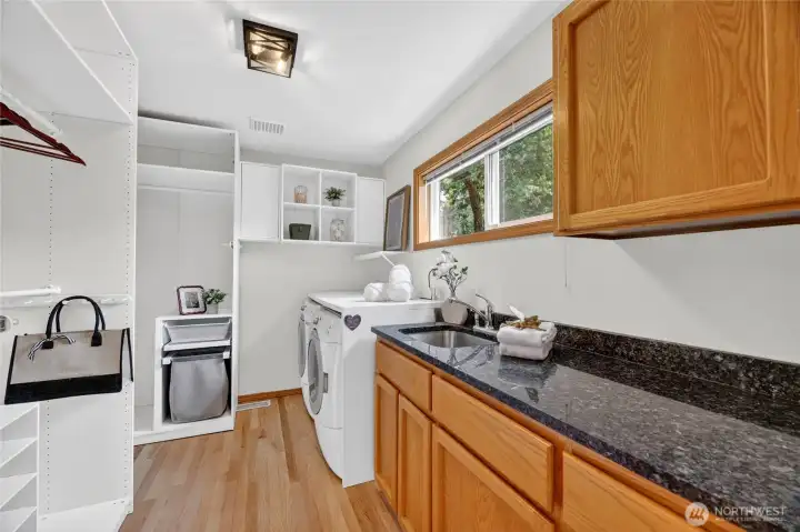 Functional utility room with built-in storage, utility sink, generous counter space, and bright natural light for everyday convenience.