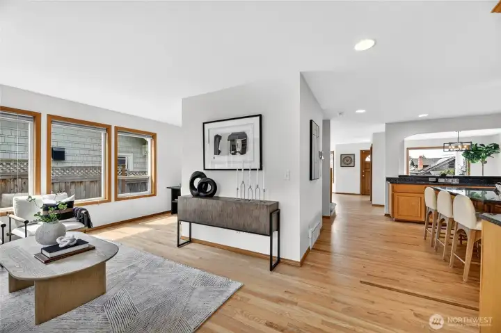 Bright open living spaces with warm hardwood floors, expansive windows, and seamless flow connecting the kitchen, dining, and gathering areas.