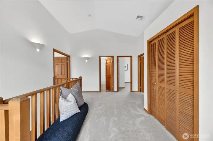 Open upper landing with vaulted ceilings, fresh carpeting, and flexible space connecting the home’s spacious private retreats.