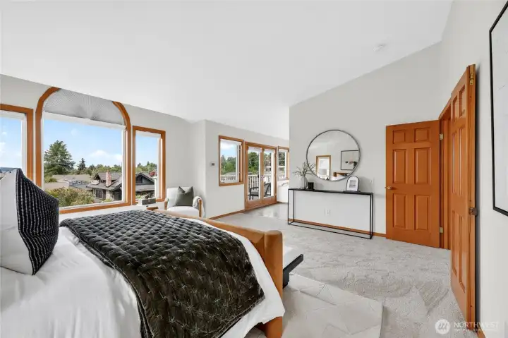 Luxurious primary retreat with panoramic windows, airy proportions, and private access to a view deck overlooking the surrounding neighborhood.
