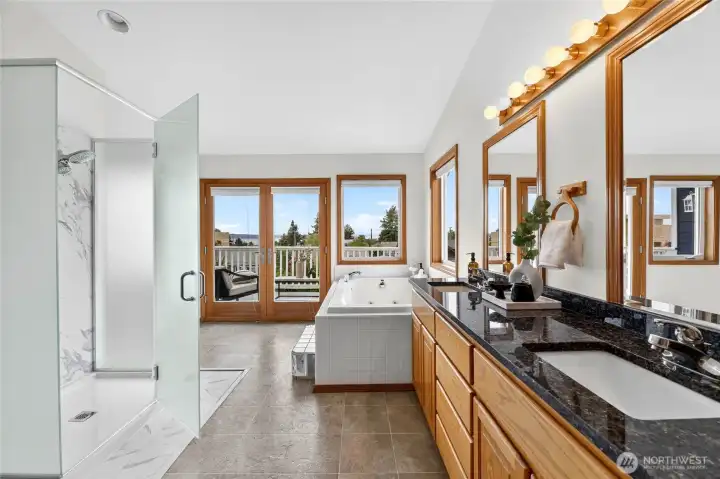 Spa-inspired primary bath with dual vanities, soaking tub, oversized walk-in shower, and private balcony access with peaceful views.