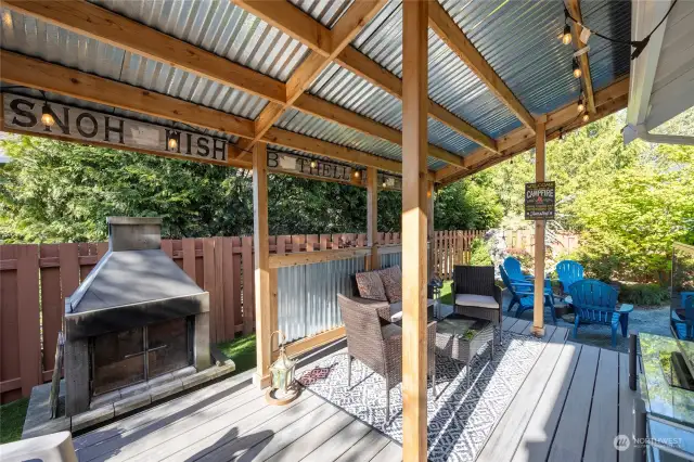 Charming covered outdoor area with wood burning fireplace, this space is so private, you are almost completely shielded from a neighbor and the street on this wonderful large corner lot