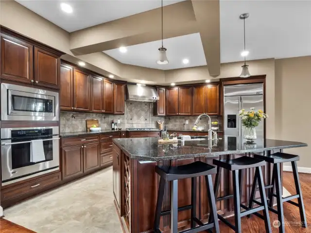 This well appointed kitchen features GE Monogram Stainless Steel appliances, beautiful cabinetry, granite countertops, walk-in pantry and abundant storage.