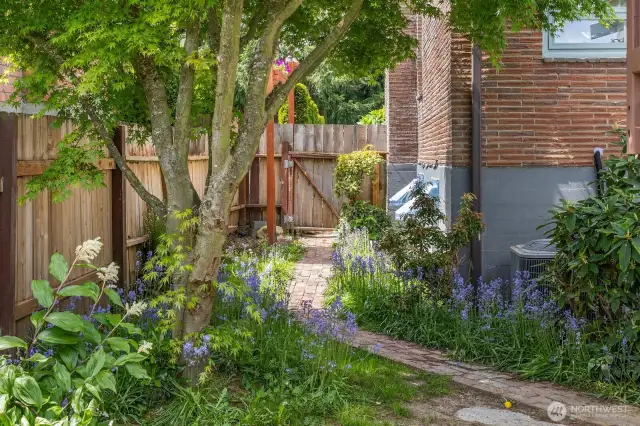 The charming brick pathway leads to the downstairs and the ample outdoor storage.