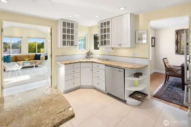 The kitchen opens into the sunroom and onto the back decks and yard.
