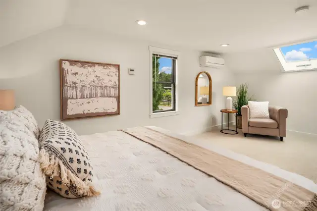 Upper floor primary bedroom with seating area, skylight and XL closet