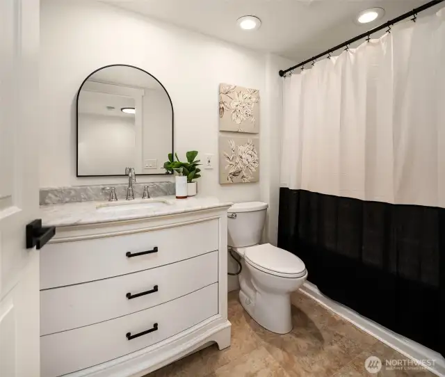 Upstairs full bath with marble countertop and tub.