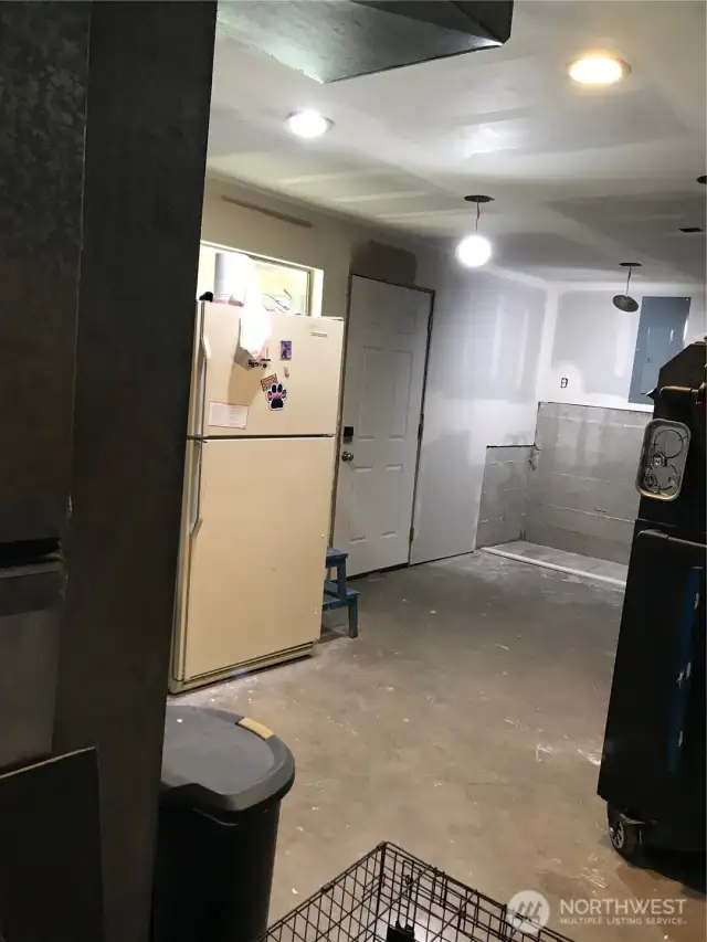 Rough finished utility area, ready for your imagination, where you will find the updated electrical panel wired for 110 or 220 generator (not included), washer and dryer (gas), Tankless water heater (gas), forced air furnace (gas),  Refrigerator does not convey.