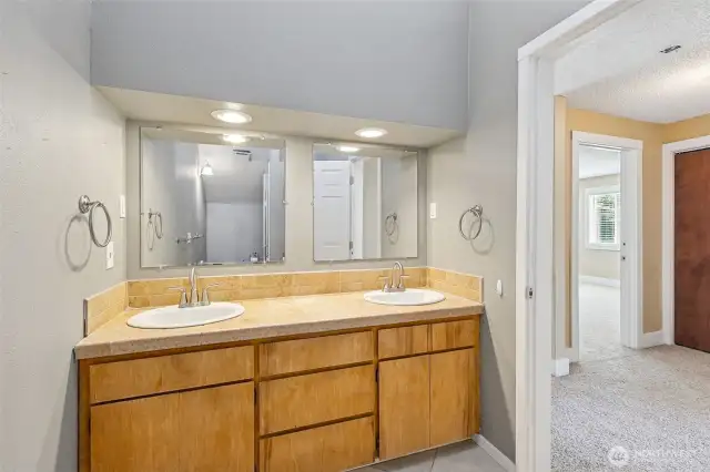 Unit B’s upstairs 3/4 bathroom combines style and privacy in all the right ways. Vaulted ceilings and high windows flood the space with natural light while keeping things private. The long vanity with dual sinks gives you plenty of space, and the tile shower with a glass door adds an extra touch of elegance. Plus, the toilet is tucked behind the shower for added privacy too!