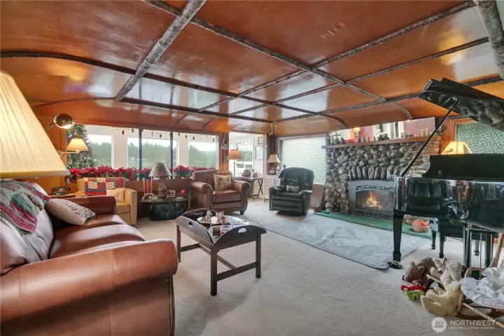 Spacious living room showcasing a stone gas fireplace with water view.