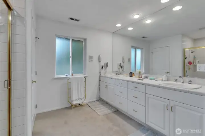 Spacious main bedroom bathroom with dual vanity, walk-in shower, and abundant storage