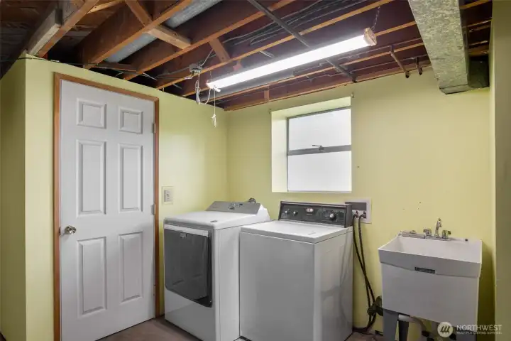 Spacious laundry area with utility sink, and storage closet