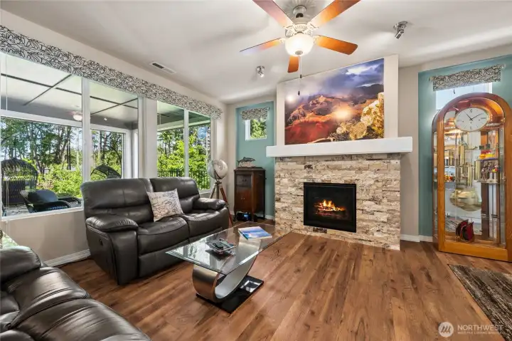 The living room is filled with natural light and a cozy gas fireplace