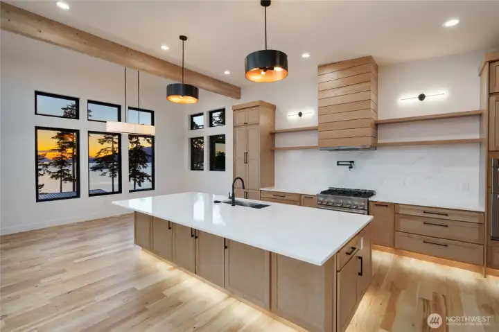 Designer chef's kitchen with quartz island and stunning water views.