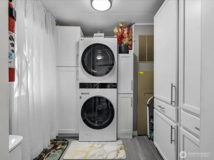 Stacked front load wash and dryer and plenty of extra storage in the utility room.