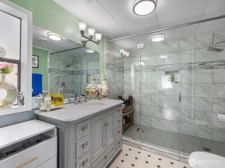 Primary bathroom with designer vanity, one of a kind walk-in shower with glass surround and rain head for that ultimate shower experience.