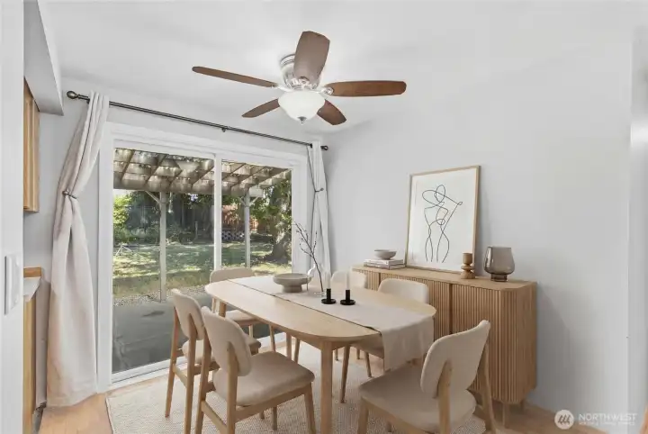 Virtually staged. Bright dining area with sliding glass doors leading to the covered patio and spacious backyard. The perfect setting for everyday meals, entertaining guests, and enjoying year-round indoor-outdoor living.