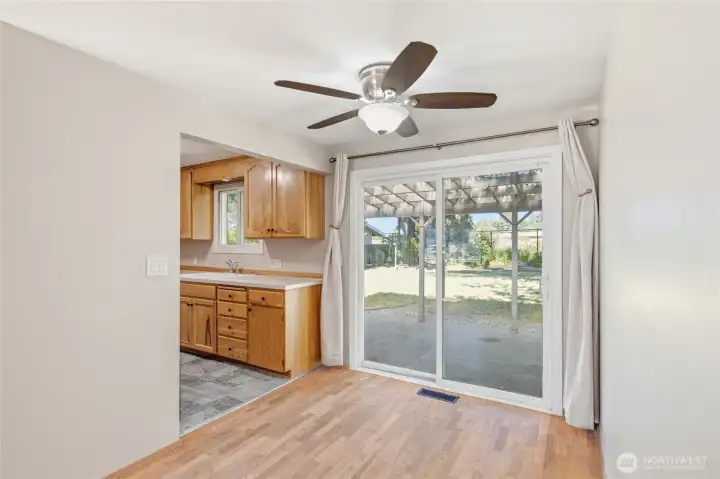Dining area with sliding glass doors opening directly to the covered patio and expansive backyard. A bright space for everyday meals, indoor-outdoor entertaining, and enjoying views of the mature landscaping.